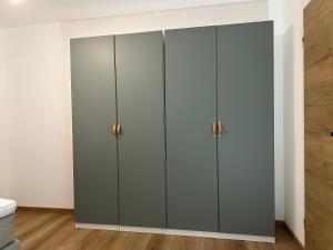 a wardrobe in a bathroom with white walls and wood floors at FeWo Immenstadt Apartment in Immenstadt im Allgäu