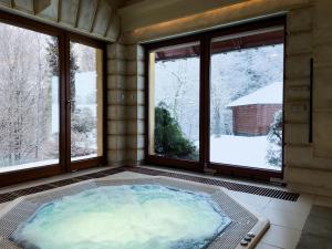 a jacuzzi tub in a room with windows at Top Mountain Villa in Wisła