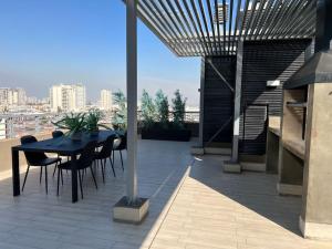 - une terrasse avec une table et des chaises dans un bâtiment dans l'établissement Depto nuevo cerca del Teatro Caupolicán y Movistar Arena, à Santiago