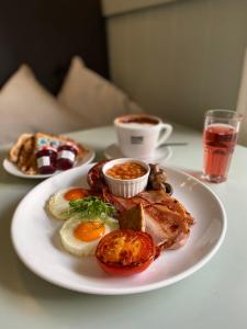 a plate of food with eggs and bacon and a cup of coffee at Mannings Hotel in Truro