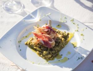 ein weißer Teller mit einem Stück Essen drauf. in der Unterkunft Hotel Tugasa El Almendral in Setenil de las Bodegas