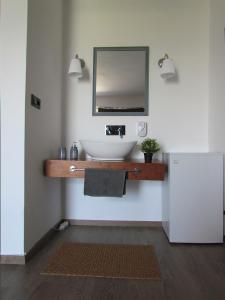 een badkamer met een wastafel en een spiegel aan de muur bij Li Mango in Tigaki