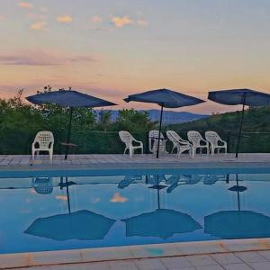 a group of chairs and umbrellas next to a swimming pool at Alto de Balcón in Tanti