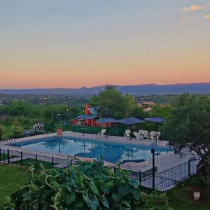 a large swimming pool with chairs and umbrellas at Alto de Balcón in Tanti