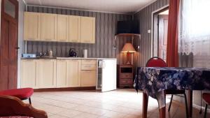 una cucina con tavolo e frigorifero bianco di OW Wilk - pokoje i domki z aneksami kuchennymi, parking, plac zabaw a Łeba