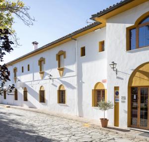 a white building with windows and a street at Hotel Tugasa El Almendral in Setenil