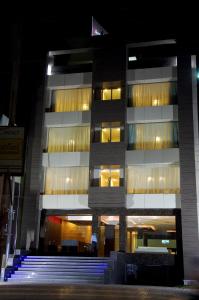 杜尔格HOTEL GARNET的一座高大的建筑,在晚上前有楼梯