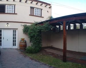 a house with a wooden pergola in front of it at MENDOZA VIÑA Y SOL cochera propia in Guaymallen