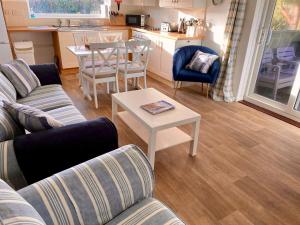 a living room with a couch and a table at Golden Acre Jurassic Coastal Lodges ,Eype in Bridport