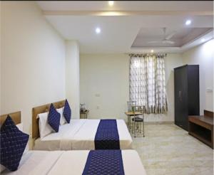 a hotel room with two beds and a television at Hotel The Best Relax Inn By WB Inn in New Delhi