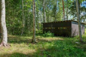een zwart gebouw midden in een bos bij Bear Watching Hide of Alutaguse in Palasi