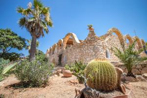una vecchia casa in pietra con un cactus di fronte di La Gariga a Lampedusa