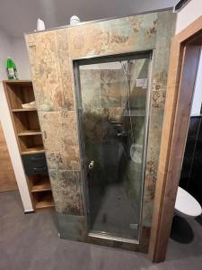 a shower with a glass door in a room at Musikbühne Flieger - das Konzept - Loften in einer Kneipe in Tettnang