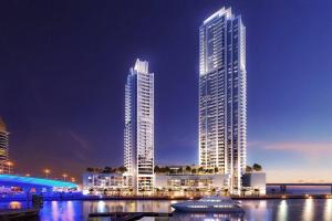 two tall skyscrapers in a city at night at Stylish 1 Bedroom in 5242 by Ofex in Dubai