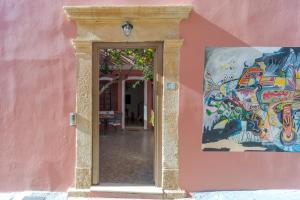 a doorway to a pink building with a painting at Palazzo Di Venus by Estia in Heraklio