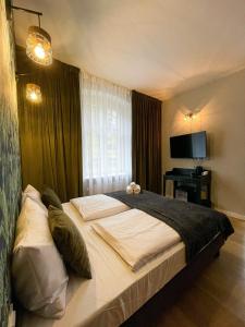 a bedroom with a large bed and a window at Perła Sudetów by Stay inn Hotels in Karpacz
