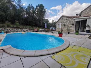 una piscina en un patio con una casa en DOMAINE DES 3 CYPRÈS Chambre PIVOINE Chez Nath & Pat, en Fumel