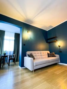カルパチにあるPerła Sudetów by Stay inn Hotelsのリビングルーム(青い壁に白いソファ付)
