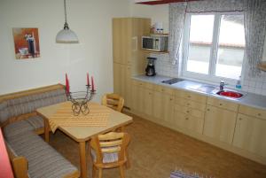 eine Küche mit einem Tisch und einem Tisch sowie ein Esszimmer in der Unterkunft Haus Königshofer in Neusiedl am See