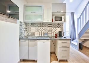 a kitchen with white cabinets and a sink and a microwave at 203.Mezzanine#4Pers#Malakoff in Malakoff