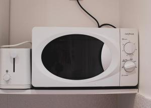 a white microwave sitting on a shelf next to a modem at 203.Mezzanine#4Pers#Malakoff in Malakoff