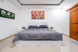 a bedroom with a large bed in a white room at Pini Sentana Village Nusa Penida in Nusa Penida