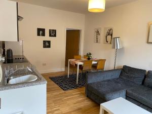 a living room with a couch and a table at Midland Apartments- one bedroom in Leicester