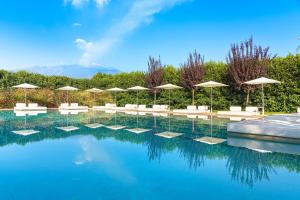 a swimming pool with umbrellas and chairs and a pool at Ramo d'Aria Etna Boutique Hotel in Giarre