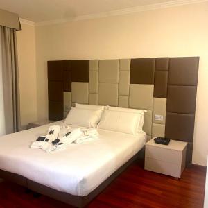 1 dormitorio con cama blanca y cabecero grande en Green Park Hotel, en Mercogliano