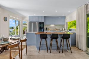 uma cozinha com armários azuis e uma mesa e cadeiras em Spacious home with ocean views em Dromana
