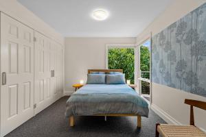 um quarto com uma cama e uma janela em Spacious home with ocean views em Dromana