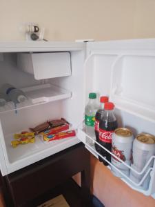 an open refrigerator with drinks and food in it at Coralca in Martínez