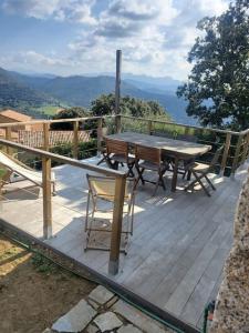 um deque de madeira com uma mesa e cadeiras em Appartement avec terrasse vue montagne em Grossa