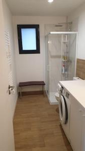 uma casa de banho com um chuveiro, um WC e uma janela. em Appartement avec terrasse vue montagne em Grossa