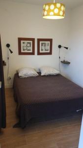 um quarto com uma cama com duas almofadas e duas luzes em Appartement avec terrasse vue montagne em Grossa