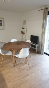 uma mesa de madeira e cadeiras numa sala de estar em Appartement avec terrasse vue montagne em Grossa