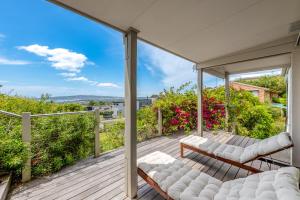 un patio con sofás blancos en una terraza de madera en Spacious home with ocean views, en Dromana