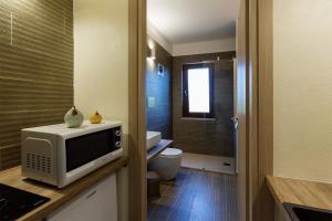 bagno con servizi igienici e TV su un bancone di Suite cucinino, bagno, ingresso indipendente in" Villa VìVì" a Siniscola