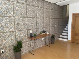um quarto com uma parede de azulejos com uma mesa e plantas em KAZARÃO DI MAVETE - Guesthouse em Praia