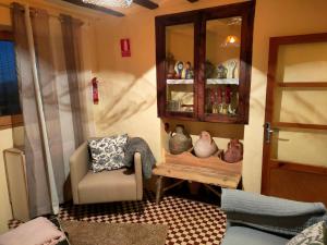 una sala de estar con una silla y un armario con jarrones en Casa Rural Bella Culla en Culla