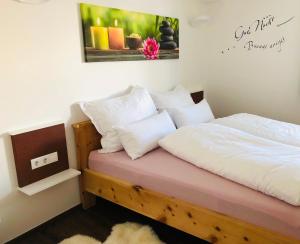 una camera da letto con un letto con lenzuola e cuscini bianchi di Ferienwohnung Steiner a Tulfes
