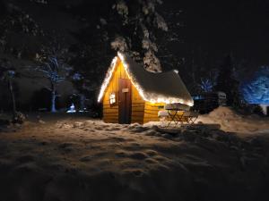 een hut met een dak bedekt met sneeuw in de nacht bij les Refuges du Chalet in Sart-lez-Spa