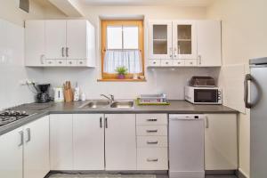 Una cocina blanca con gabinetes blancos y un fregadero. en Domki pod Tatrami, en Zakopane