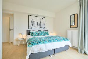 a bedroom with a large bed with blue pillows at Diamant 3 Bedroom in Brussels