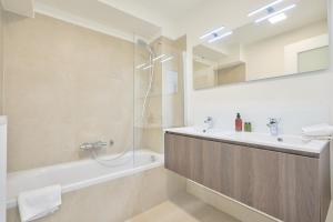 La salle de bains est pourvue d'une baignoire, d'un lavabo et d'une douche. dans l'établissement Diamant 3 Bedroom, à Bruxelles
