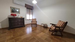 a living room with two chairs and a dresser at Holiday Maria Luisa in Galtellì