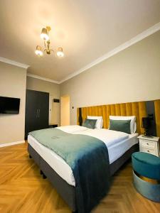 1 dormitorio con 1 cama grande y 1 silla azul en Perła Sudetów by Stay inn Hotels, en Karpacz