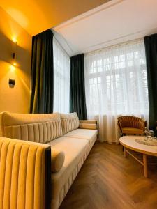 カルパチにあるPerła Sudetów by Stay inn Hotelsのリビングルーム(ソファ、テーブル付)