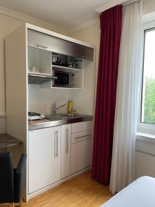 a kitchen with a sink and a microwave at Swiss Star Irchel - Self Check-In in Zurich