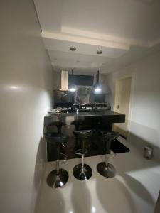 uma cozinha com um balcão preto e bancos em CaSa CLEAN PARATY em Paraty